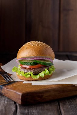Tahtadaki hamburgerler karanlık arka planda..