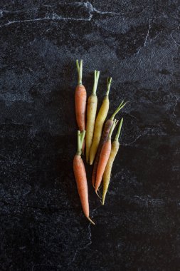 Siyah arka planda havuç. Mesaj için hasat arkaplanı kavramı. Düz konum, üst görünüm, metin için boşluk kopyala. Siyah beton arka planda sebze hasat et