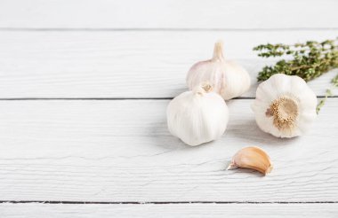 Beyaz ahşap arka planda kekik ve sarımsak. Sağlıklı gıda kavramı. Uzayı metin için kopyala. Üst görünüm, düz görünüm, uzan