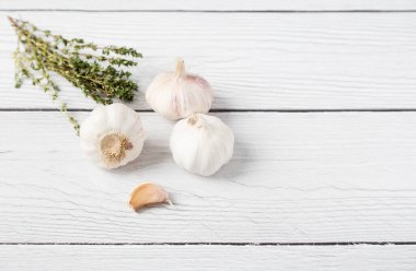 Beyaz ahşap arka planda kekik ve sarımsak. Sağlıklı gıda kavramı. Uzayı metin için kopyala. Üst görünüm, düz görünüm, uzan