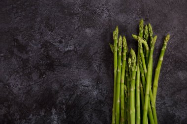 Uzayı koyu beton arka planda kuşkonmazla kopyalayın. Metin için sağlıklı yiyecek malzemeleriyle fotokopi alanı ile çerçevele. Üst görünüm, düz görünüm, yukarıdan görüntü