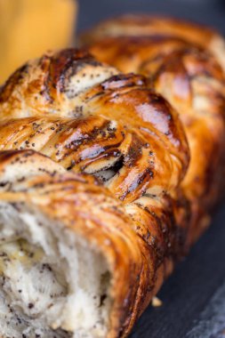 Makro haşhaş tohumları koyu arkaplanda yuvarlanır. Taze pastane ürünleri kavramı