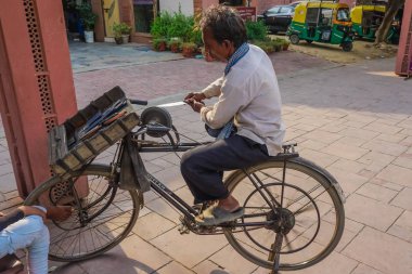 Agra, Hindistan - 29 Ekim 2017: Hintli adam bisiklet bileyicisiyle bıçakları biliyor.