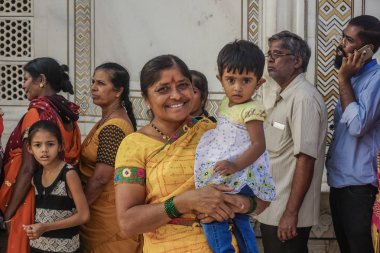 Agra, Hindistan - 29 Ekim 2017: Kollarında bebeği olan gülümseyen Hintli kadın