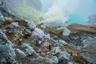 Ijen Volcano, Indonesia - April 1, 2018: Workers mine sulfur from the crater of the volcano