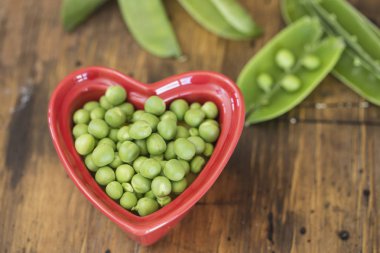 Kırmızı bir kalp yeşil bezelye kase şeklinde