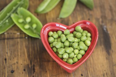 Kırmızı bir kalp yeşil bezelye kase şeklinde