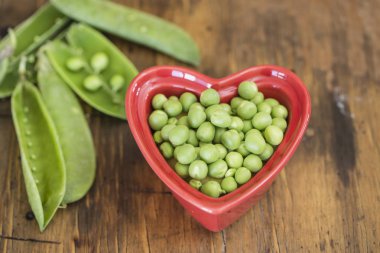 Kırmızı bir kalp yeşil bezelye kase şeklinde