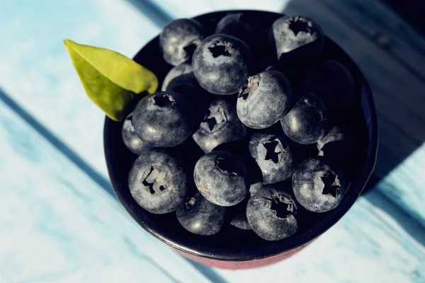 Ripe freshly picked blueberries in a blue background table — Stock Photo, Image