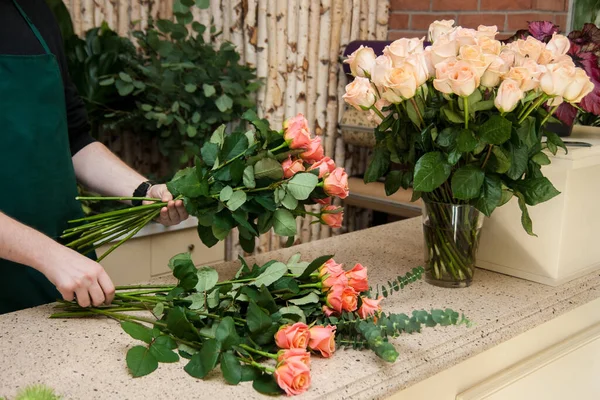 Florist arranging a bouquet of roses