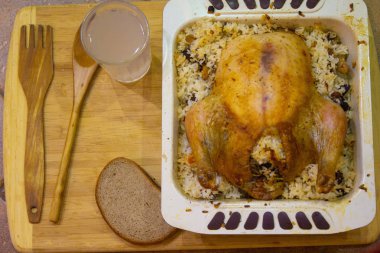 Pilavlı fırında tavuk, bir bardak kvass, bir parça ekmek, ahşap çatal ve kaşık.