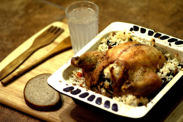 Baked chicken with rice, a glass of kvass, a piece of bread, a wooden fork and spoon