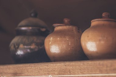 Rafta kapaklı bir sıra kil çömlek - köylü yemekleri