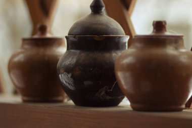 Rafta kapaklı bir sıra kil çömlek - köylü yemekleri