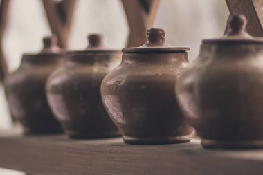 Rafta kapaklı bir sıra kil çömlek - köylü yemekleri