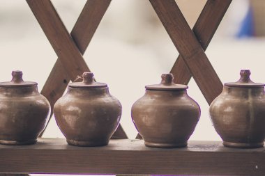 Rafta kapaklı bir sıra kil çömlek - köylü yemekleri