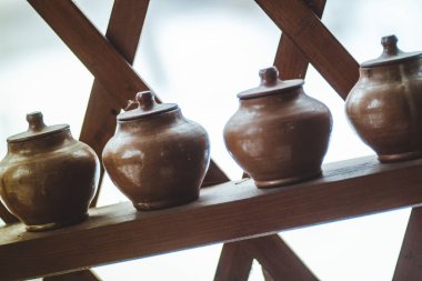 Rafta kapaklı bir sıra kil çömlek - köylü yemekleri