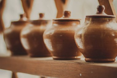 Rafta kapaklı bir sıra kil çömlek - köylü yemekleri