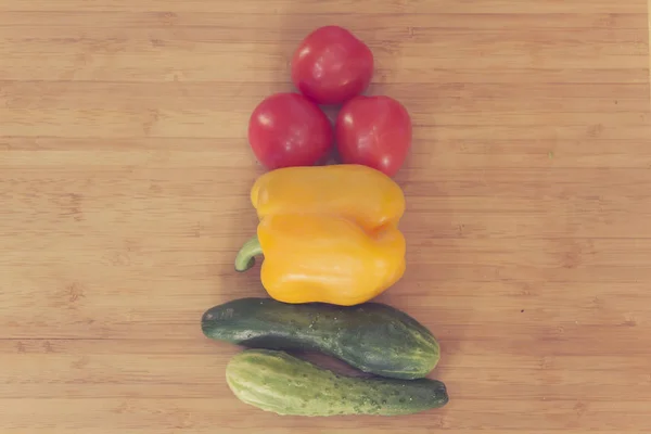 Traffic light from vegetables: red tomato, yellow pepper, green cucumber