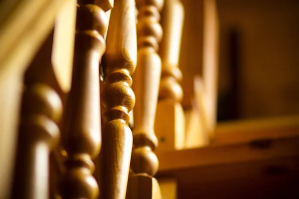 Wooden balusters on wooden railings on the stairs in a rural house