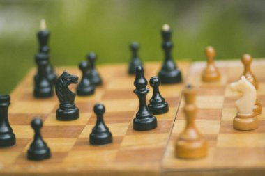 Satranç oynamak için tahta bir satranç tahtasında siyah ve beyaz taşlar