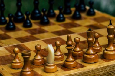 Satranç oynamak için tahta bir satranç tahtasında siyah ve beyaz taşlar