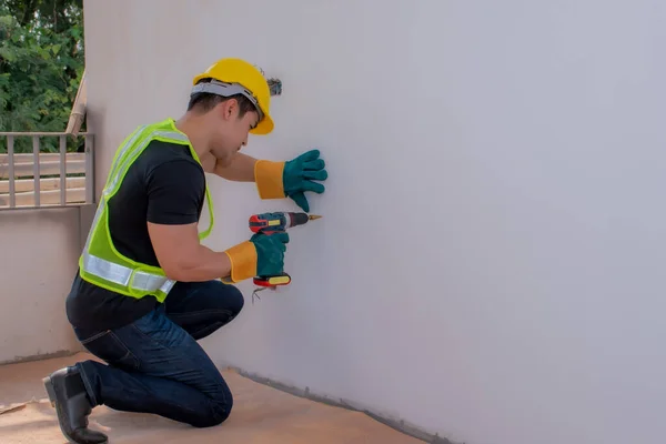 強い男性労働者は壁に侵入し 男性のために懸命に働く 強い労働者 壁にピアス ヘルメットの男 建物の修復と改装の概念 — ストック写真