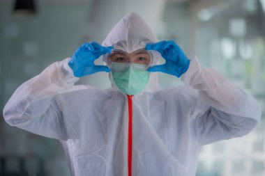Bilim adamları laboratuarda maske, eldiven ve koruyucu giysiler giyerler..