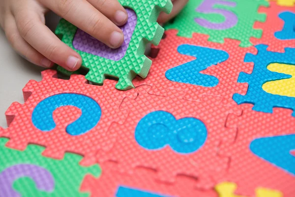 Criança jogando quebra-cabeças alfabeto — Fotografia de Stock