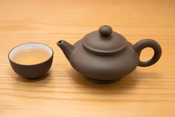 Side view cup of tea and teapot on wood table — Stock Photo, Image