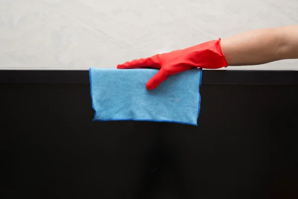 Muž v červených gumových rukavic čištění tv s modrým ubrouskem — Stock fotografie