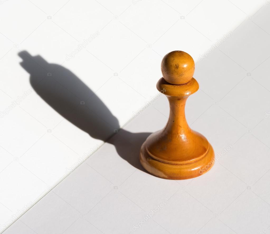 a chess pawn casting a king piece shadow concept of strength and aspirations