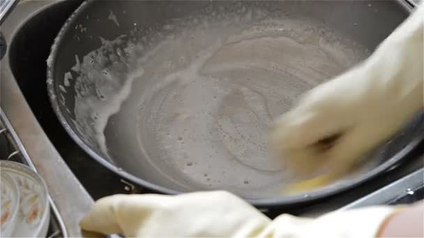 Uomo che lava una padella nel lavello della cucina con spugna saponata — Video Stock