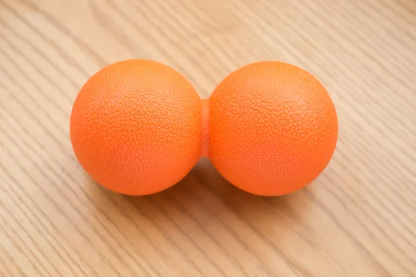 Petite boule de massage orange sur une table en bois — Photo