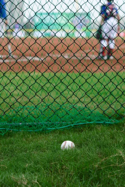 Baseball utanför ett baseball fält med smeten och catcher på bakgrunden selektivt fokus — Stockfoto