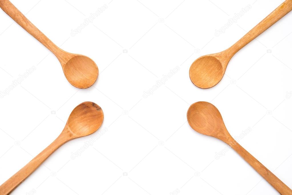 four empty wooden spoons on white background