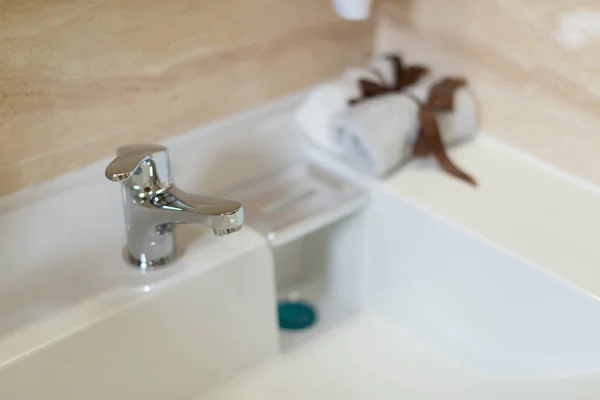Lavatório limpo e torneira de aço inoxidável em um banheiro — Fotografia de Stock