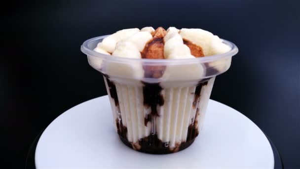 黒い背景 4 k にチョコレート味のアイスクリームのカップ — ストック動画