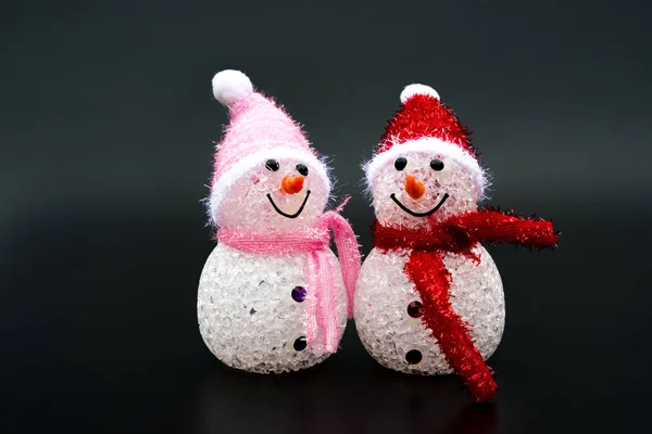 Dwa uśmiechający się zabawka christmas snowman na czarnym tle — Zdjęcie stockowe