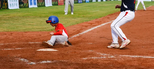 Player körs till basen för att få en punkt i en baseball match — Stockfoto