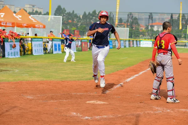 Jugador corriendo a la base para conseguir un punto en un partido de béisbol — Foto de Stock