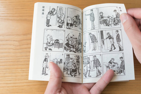 ZhongShan China-January 4:man reading a comic book named Old Master Q on January 4 2017.Old Master Q is a popular Hong Kong comic created by Alfonso Wong and appeared in 1962 and serialised in 1964.