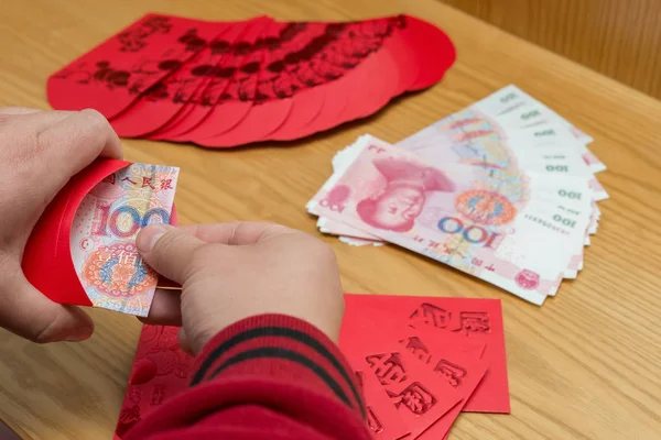 Man preparing a red pocket with Chinese paper currency — Stock Photo, Image