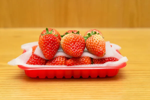 Paquete de fresas frescas vista lateral en la mesa de madera — Foto de Stock