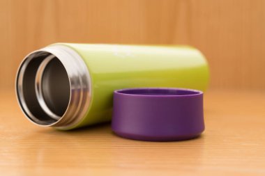ahşap bir masa üzerinde yeşil vakum tumbler