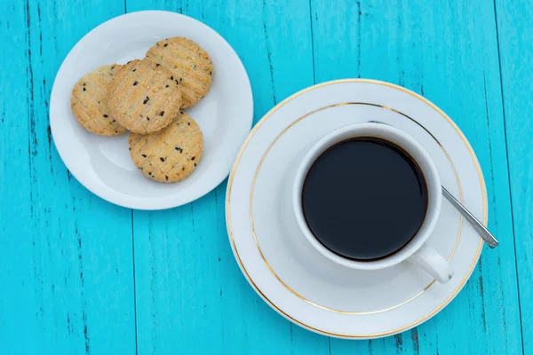 Vista dall'alto tazza di caffè e biscotti con seasame su sfondo blu — Foto Stock