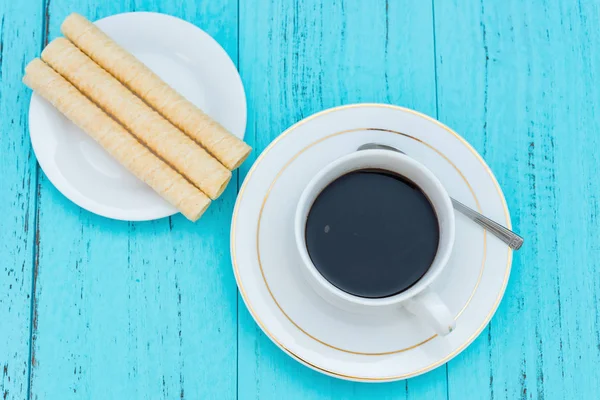 Ovanifrån kopp kaffe och ägg rullar på en blå bakgrund — Stockfoto