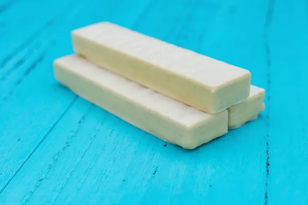 Gaufrette chocolat blanc vue de côté avec plat sur fond bleu — Photo