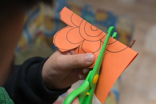 Gamin faire la coupe de papier à la maison — Photo