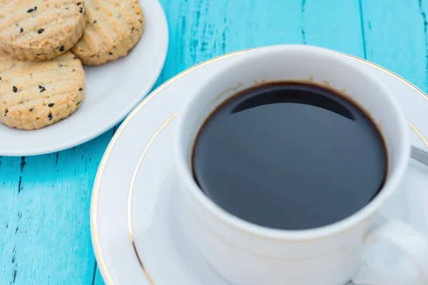 Up kahve ve bisküvi seasame üzerinde mavi arka plan ile — Stok fotoğraf